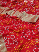 A red and silver bandhani style silk saree with mirror handwork, including floral patterns and a traditional design.