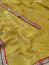 A yellow and red tissue silk saree with Bollywood style embellishments and gotapatti work.