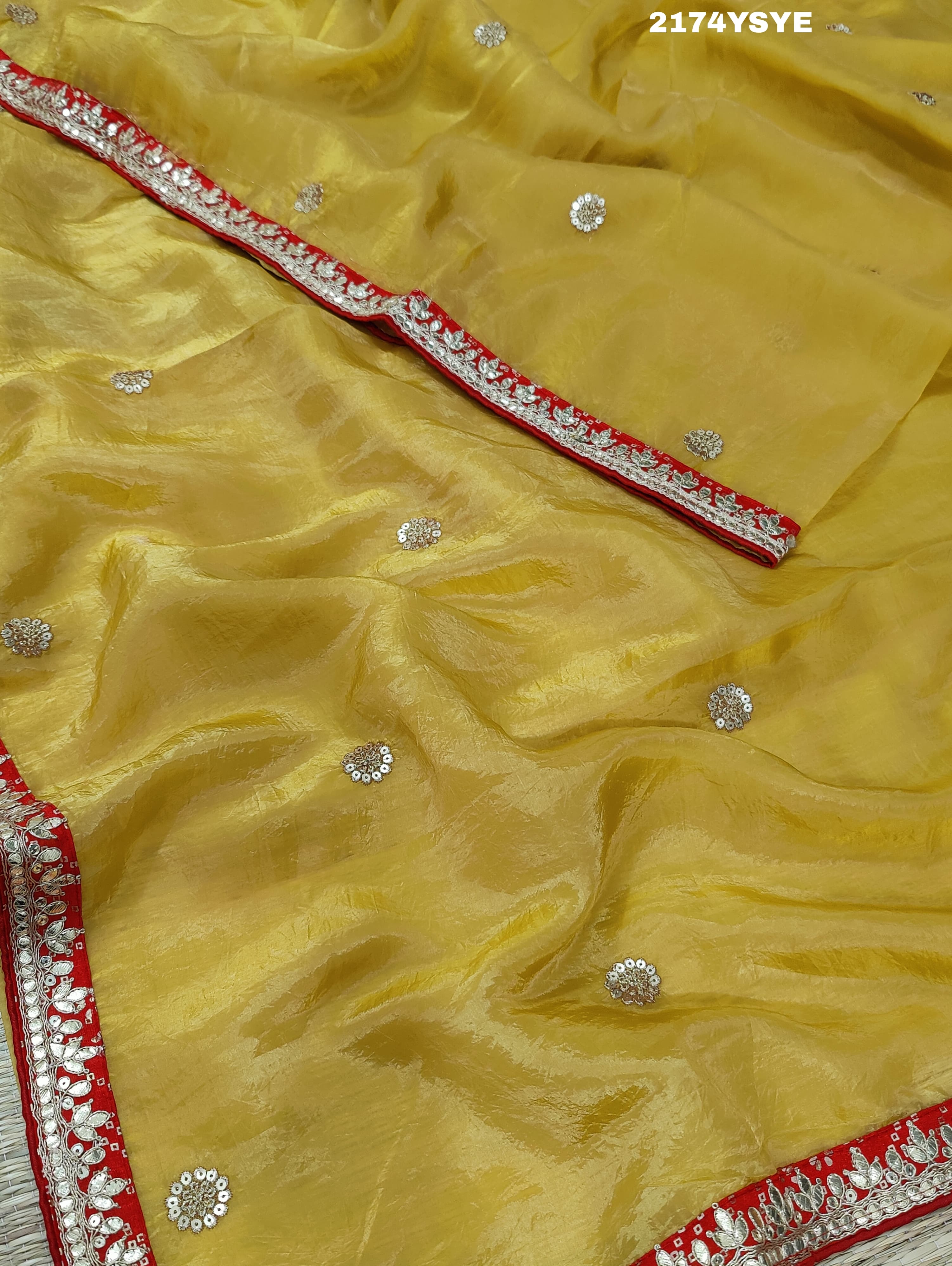A yellow and red tissue silk saree with Bollywood style embellishments and gotapatti work.