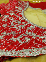 A yellow and red tissue silk saree with Bollywood style embellishments and gotapatti work.