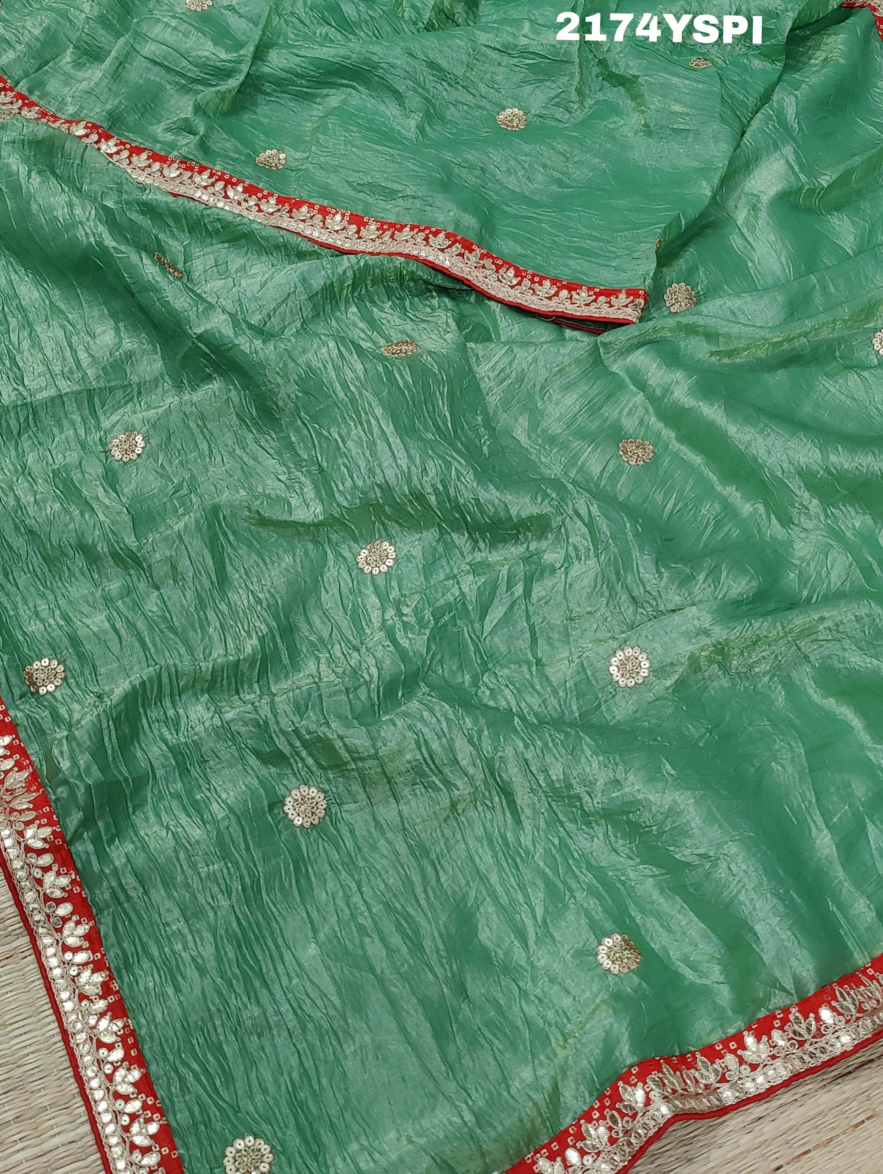 A green and red tissue silk saree with Bollywood style embellishments and gotapatti work.