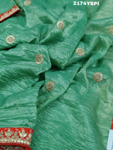 A green and red tissue silk saree with Bollywood style embellishments and gotapatti work.
