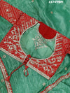 A green and red tissue silk saree with Bollywood style embellishments and gotapatti work.
