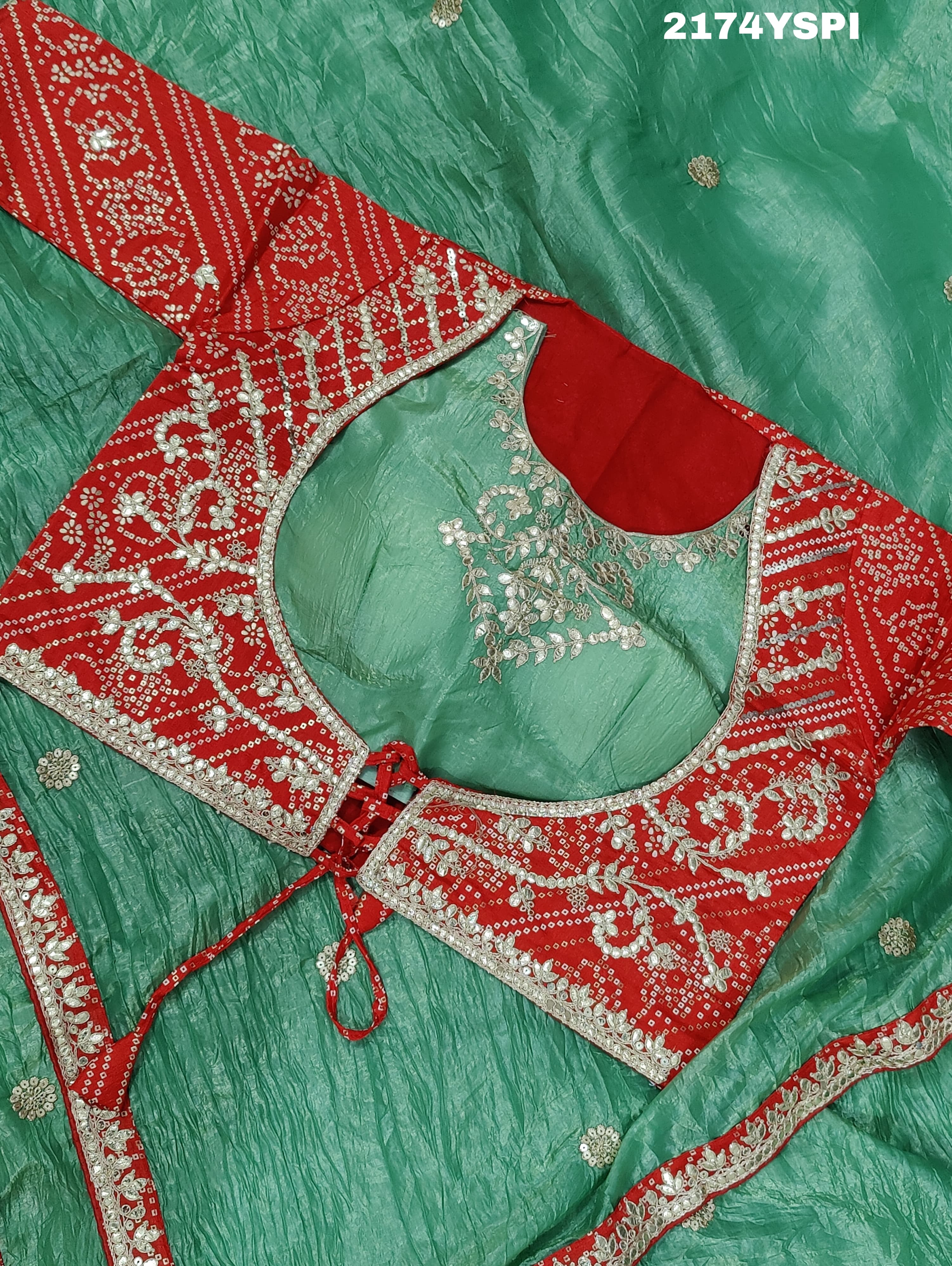 A green and red tissue silk saree with Bollywood style embellishments and gotapatti work.