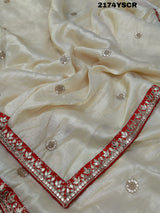A red and white tissue silk saree with Bollywood style embellishments and gotapatti work.