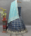 A traditional Indian lehenga with a blue and silver silk base and detailed cutdana work