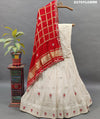 A traditional Indian lehenga in cream and red color with gotapatti work