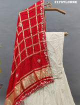 A traditional Indian lehenga in cream and red color with gotapatti work