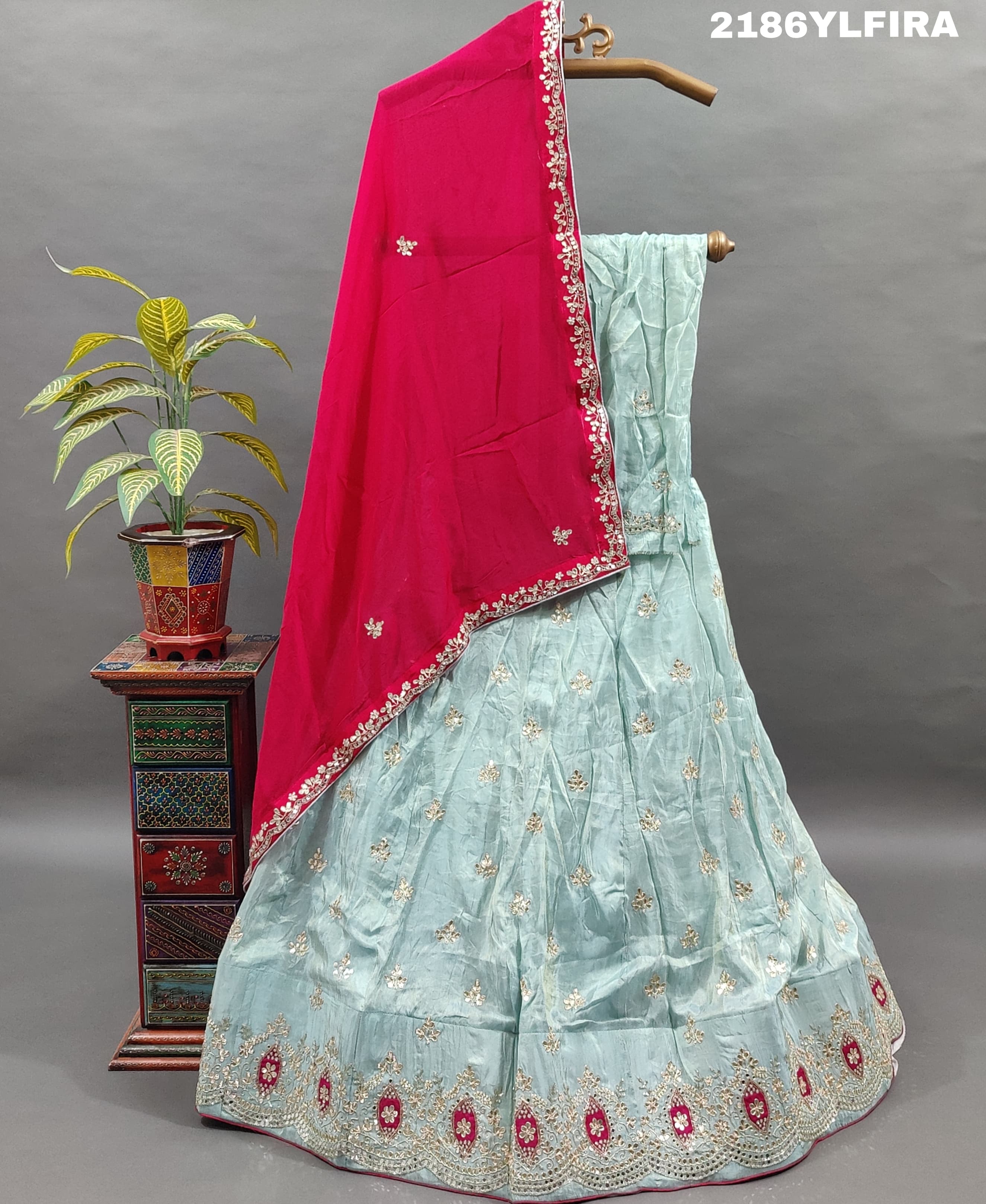 A Bollywood style blue Lehenga with pink embellishments and a red dupatta.