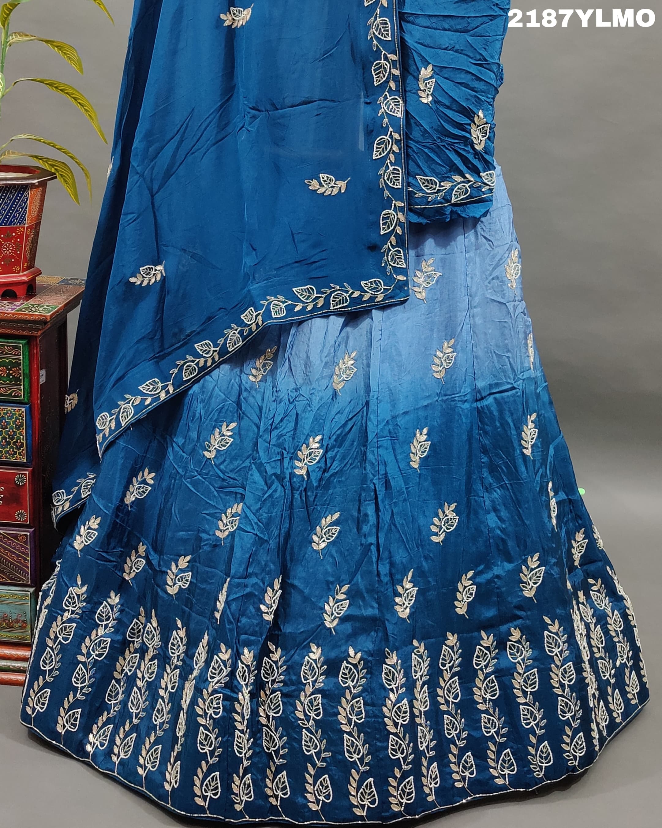 A blue traditional style silk lehenga with white bead work
