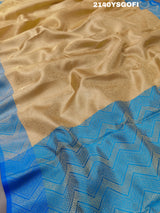 A tissue silk banarasi saree with zari weaving, featuring a blue and gold design on a beige fabric, meant for party or casual wear.
