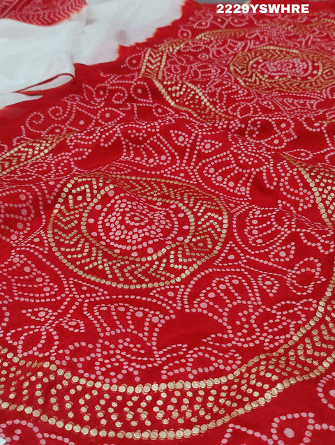 A traditional saree with red and white colors and intricate patterns, predominantly red at one end with a floral design.