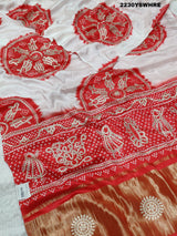 A red and white bandhani style saree with gotapatti work