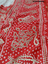A red and white bandhani style saree with gotapatti work