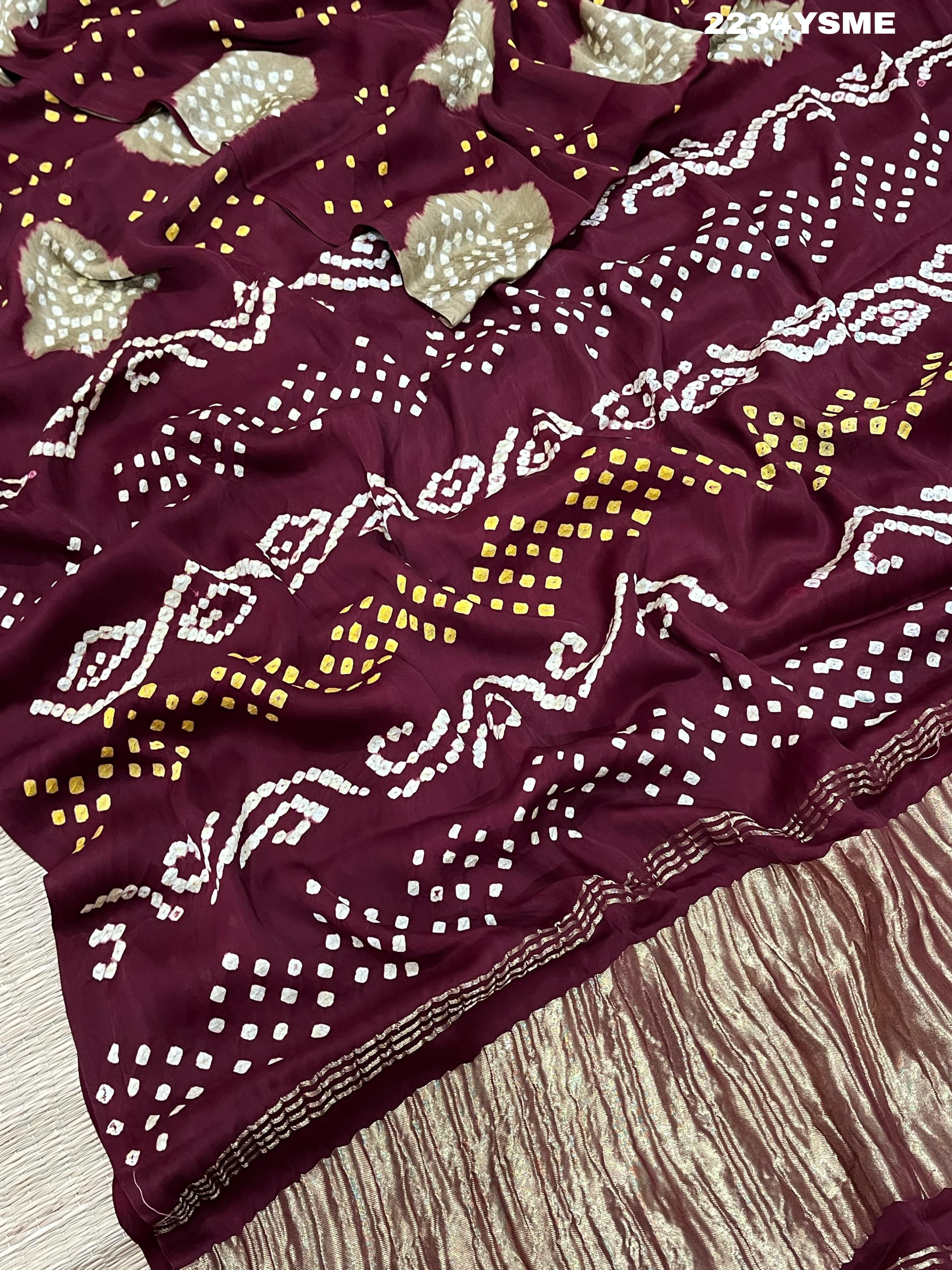 A maroon and white colored bandhani style saree 