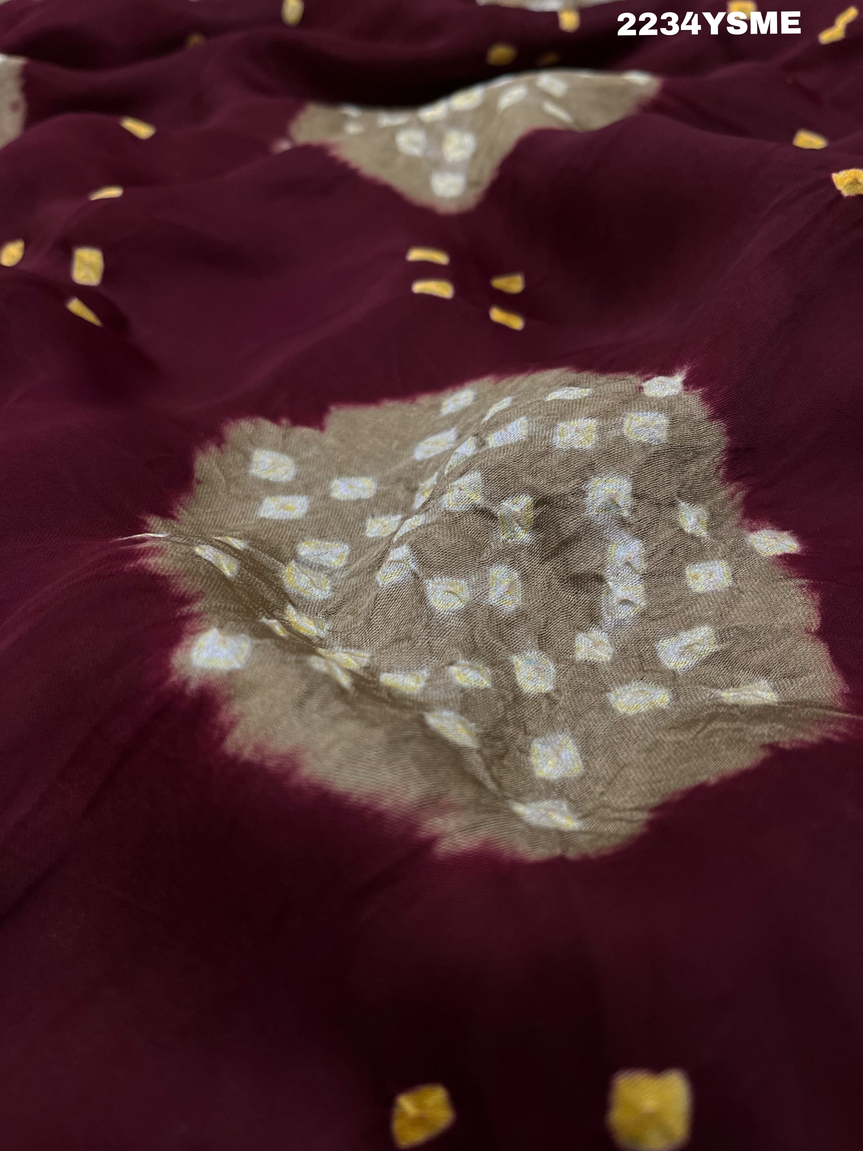 A maroon and white colored bandhani style saree 