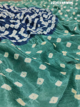 A silk fabric saree with bandhani style patterns in blue and green colors