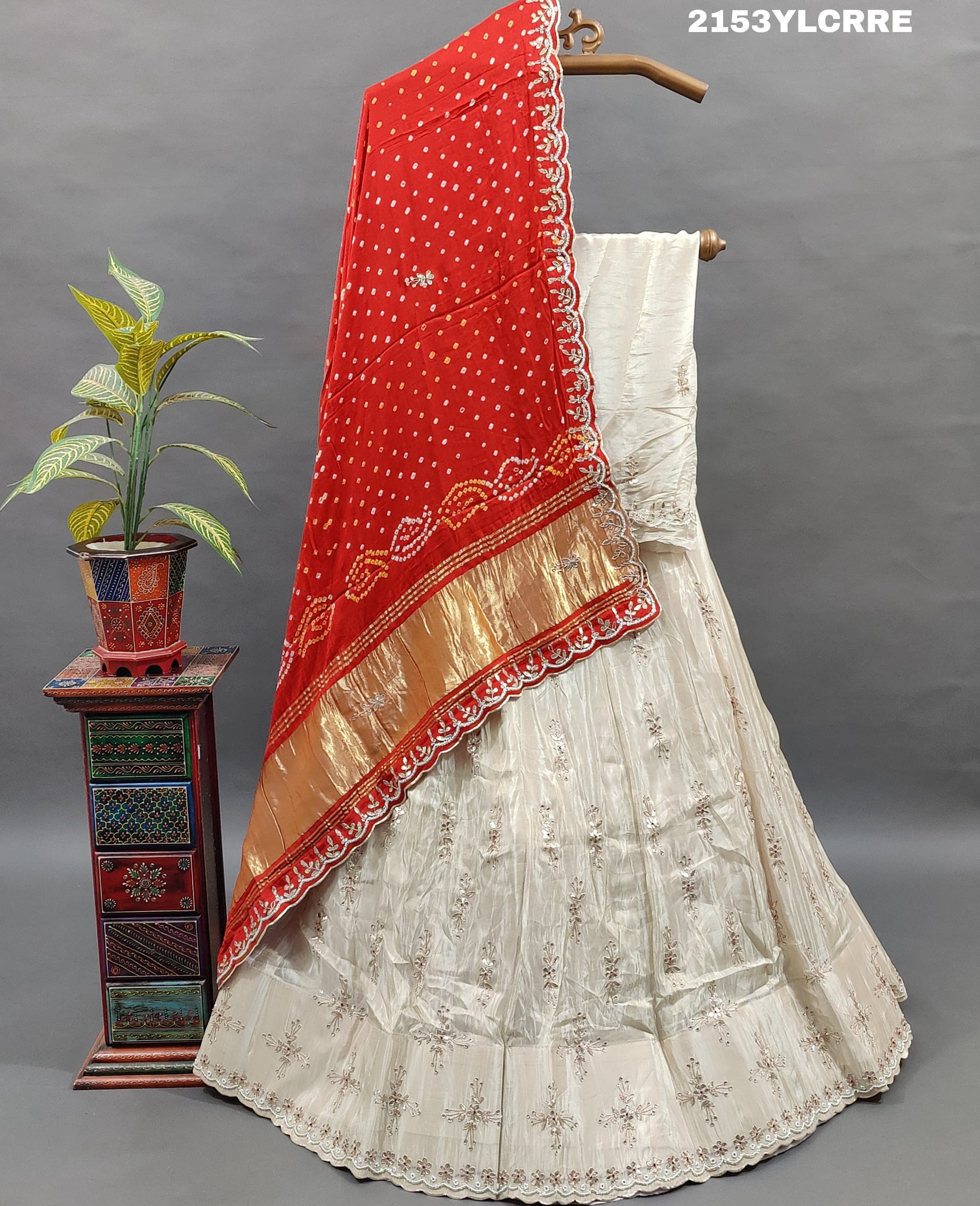 A traditional wear lehenga with bandhani style in red and cream colors 