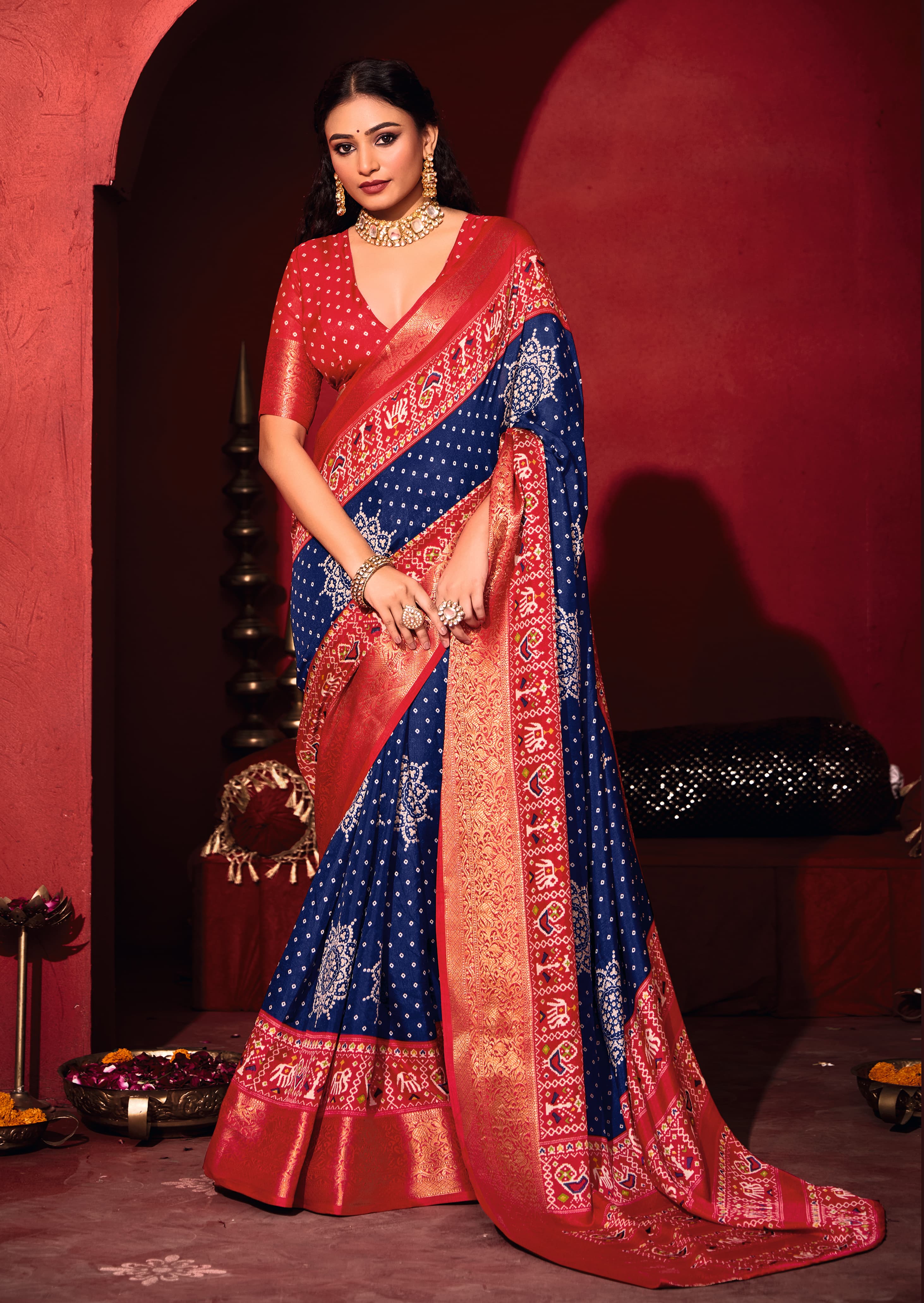 A blue and red bandhani print pashmina silk saree with patola print border