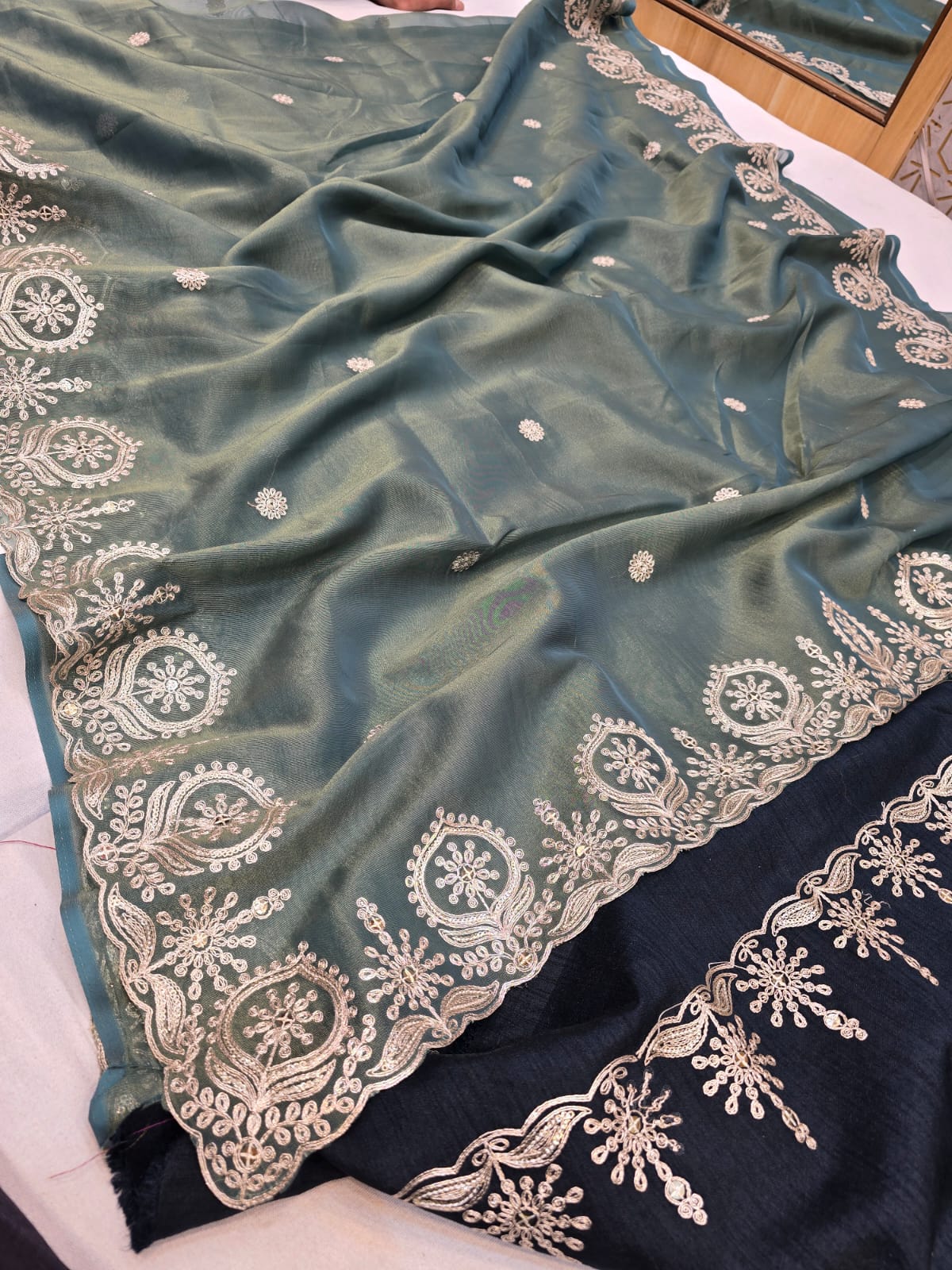 A green and black viscose tissue saree with zari and pittan work
