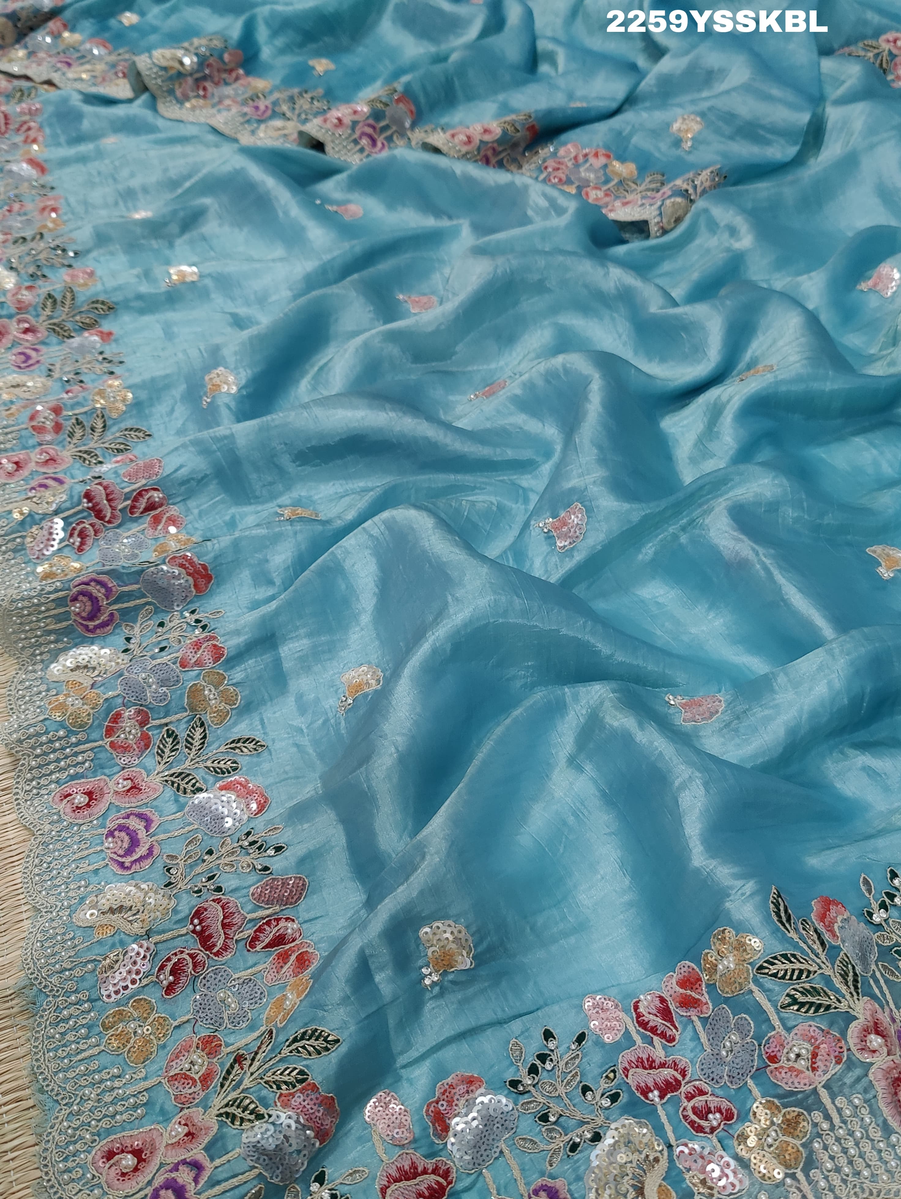 A blue saree with tissue silk fabric and Bollywood-style sequence embroidery work, including floral patterns and a border.