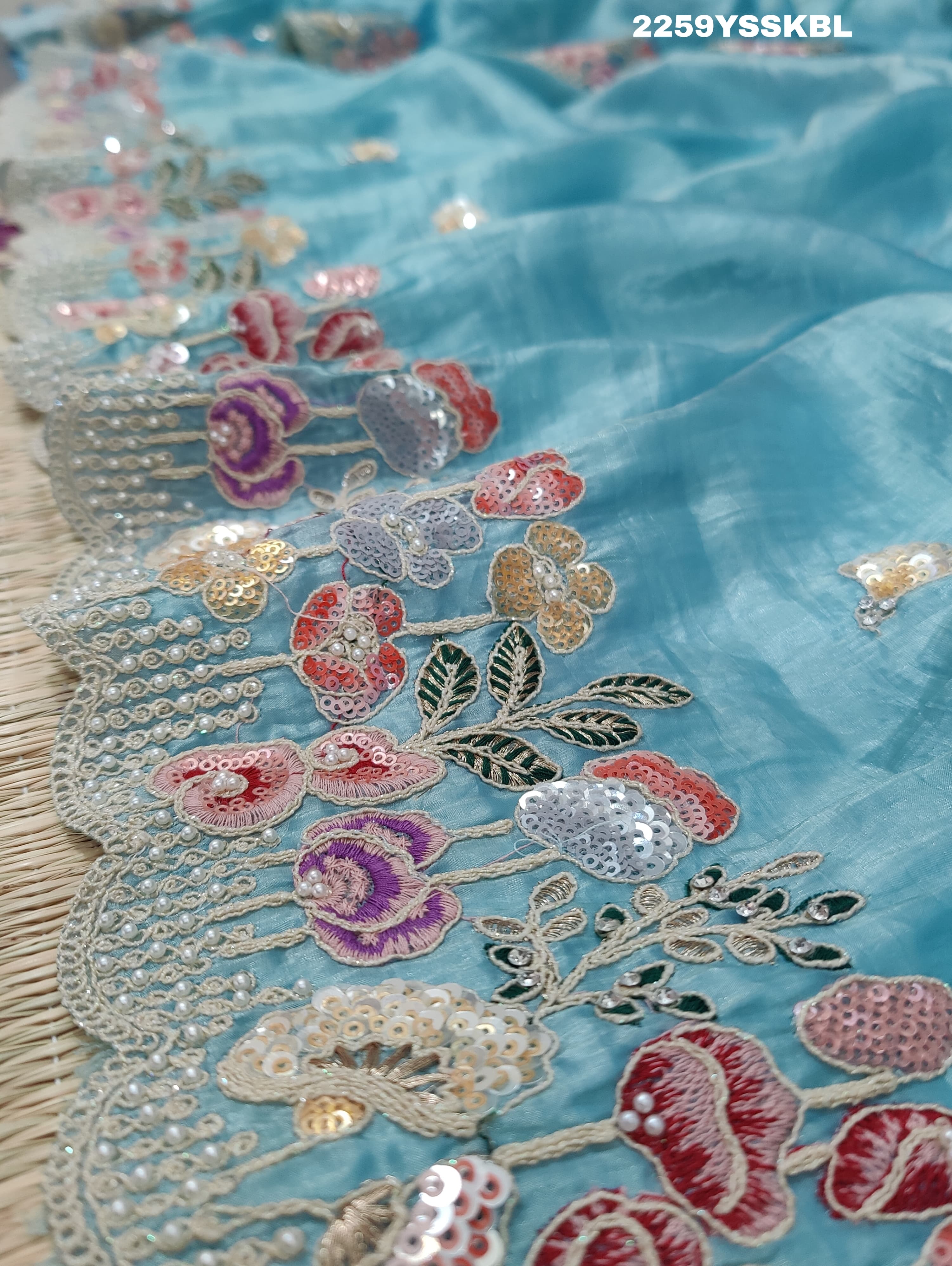 A blue saree with tissue silk fabric and Bollywood-style sequence embroidery work, including floral patterns and a border.