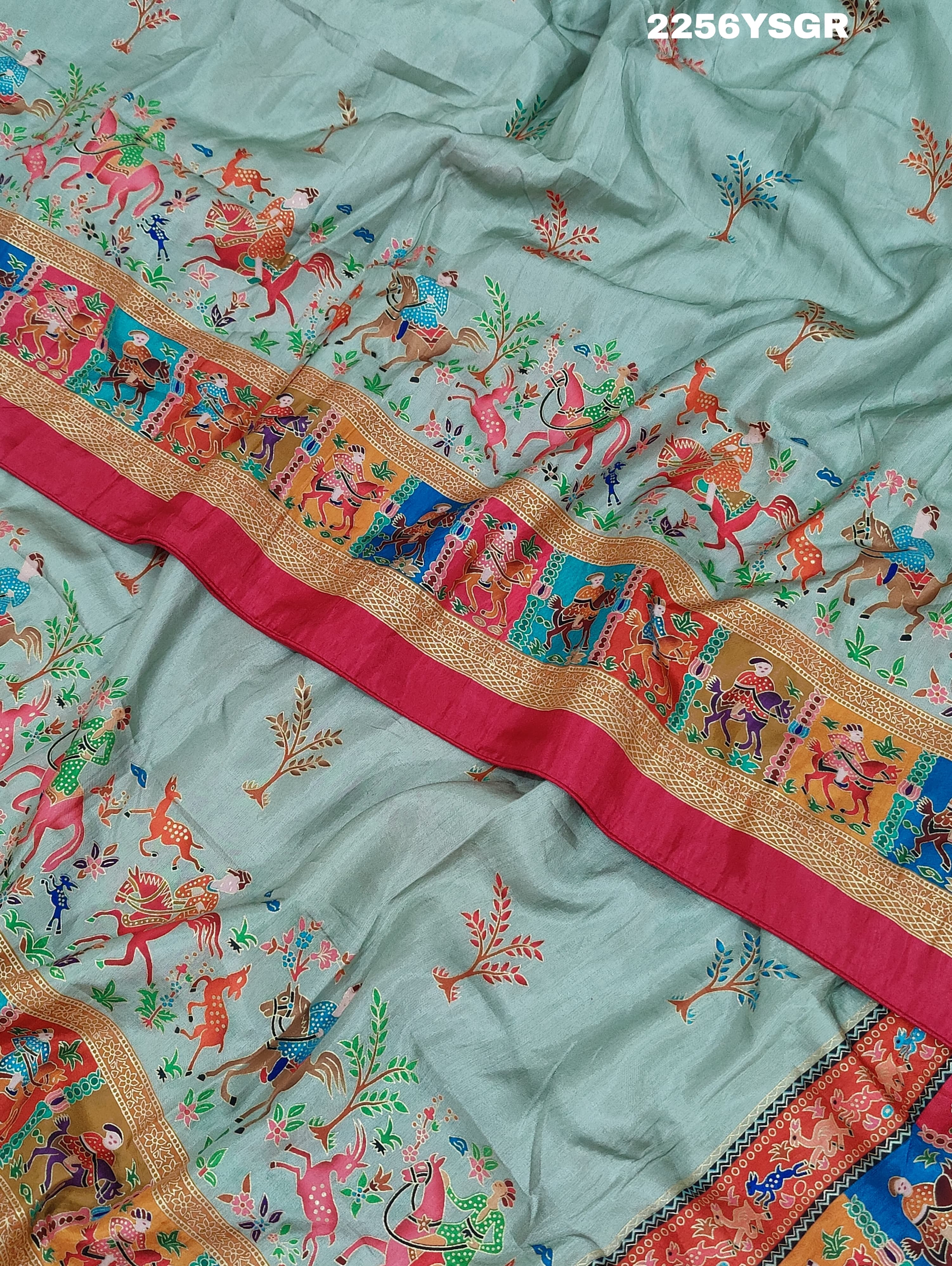A cotton silk saree with a kalamkari style foil print design featuring multiple colors including red, green, and beige.