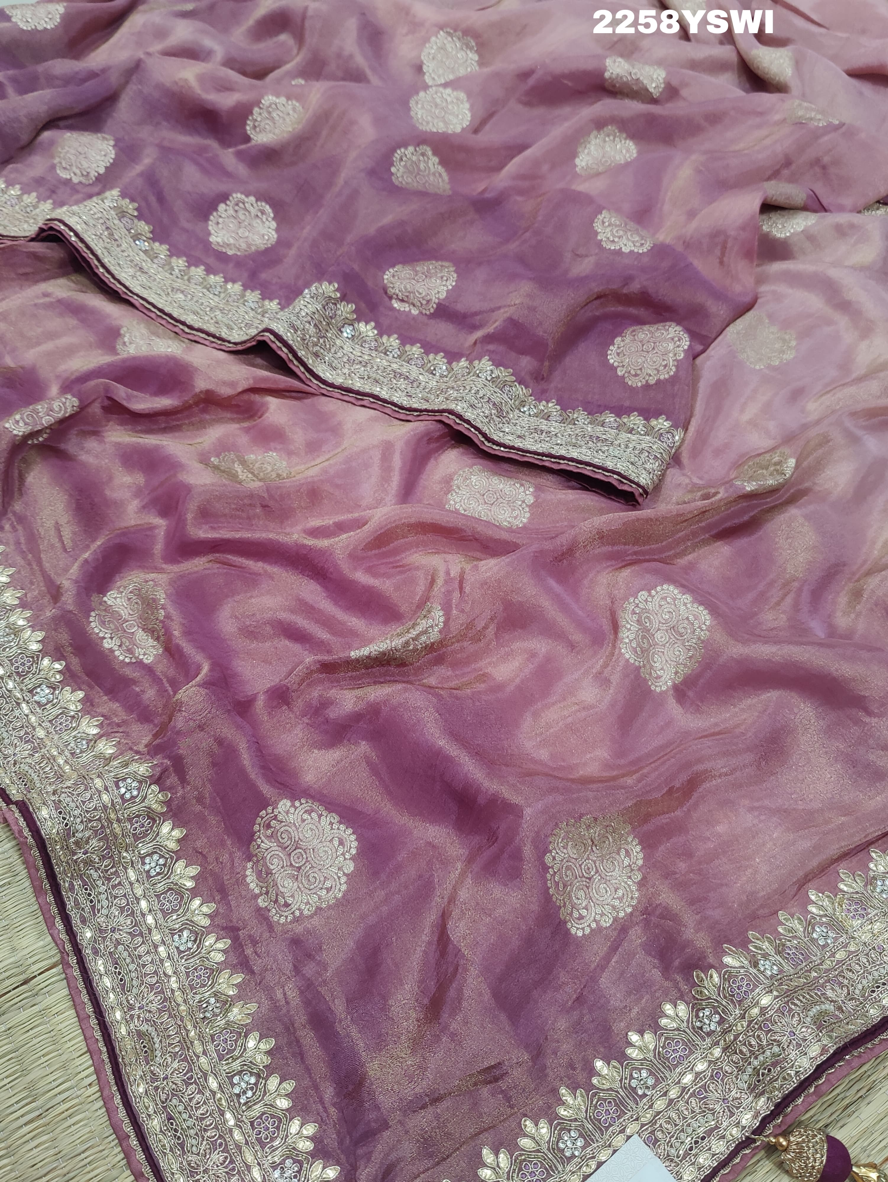 A purple Banarasi silk saree with Bollywood-style embellishments including sequins and gotapatti work, 