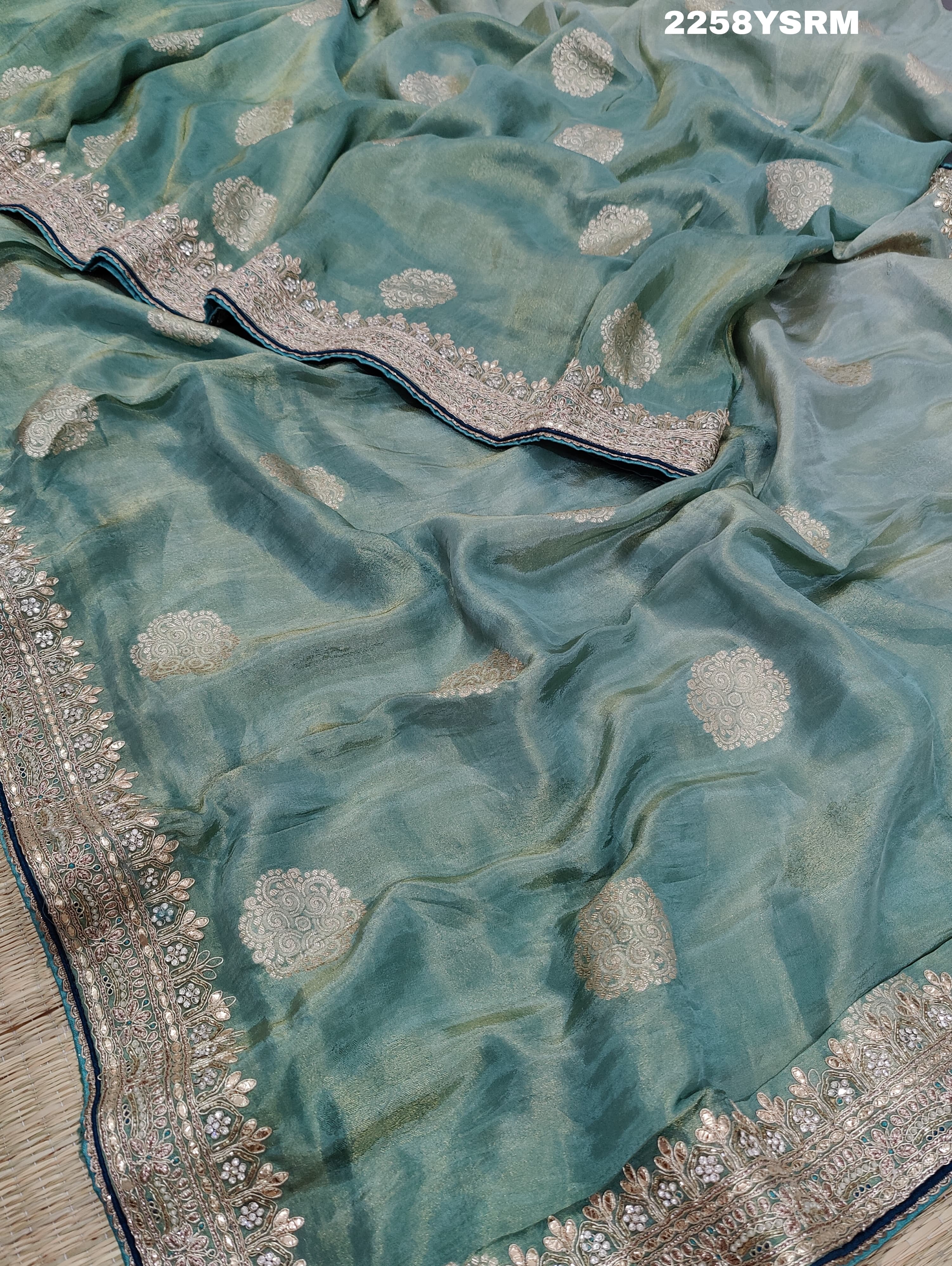A sea green Banarasi silk saree with Bollywood style embellishments including sequins and gotapatti work
