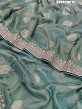 A sea green Banarasi silk saree with Bollywood style embellishments including sequins and gotapatti work