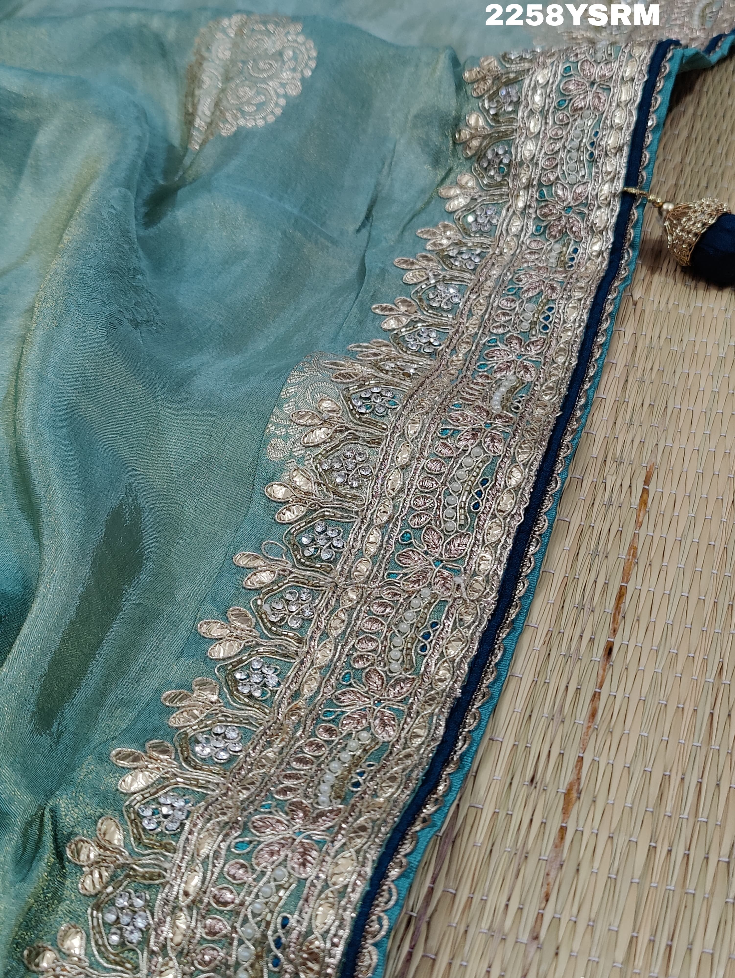 A sea green Banarasi silk saree with Bollywood style embellishments including sequins and gotapatti work