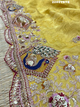 A yellow Banarasi silk saree with Bollywood style embellishments including sequins and a distinctive pattern.