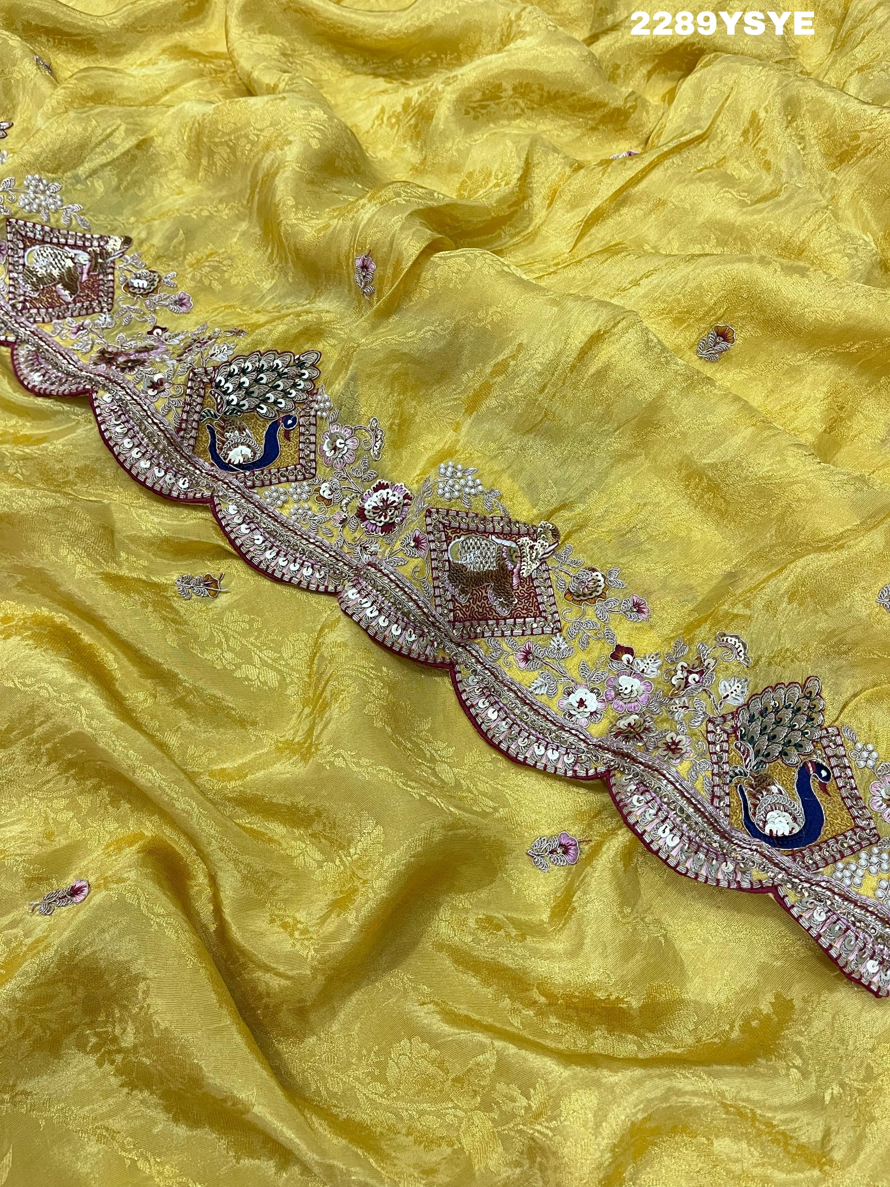 A yellow Banarasi silk saree with Bollywood style embellishments including sequins and a distinctive pattern.