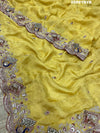 A yellow Banarasi silk saree with Bollywood style embellishments including sequins and a distinctive pattern.
