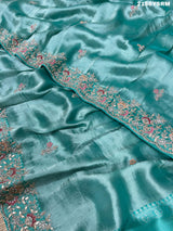 A sea green tissue silk saree with sequence embroidery work in a Bollywood style pattern.