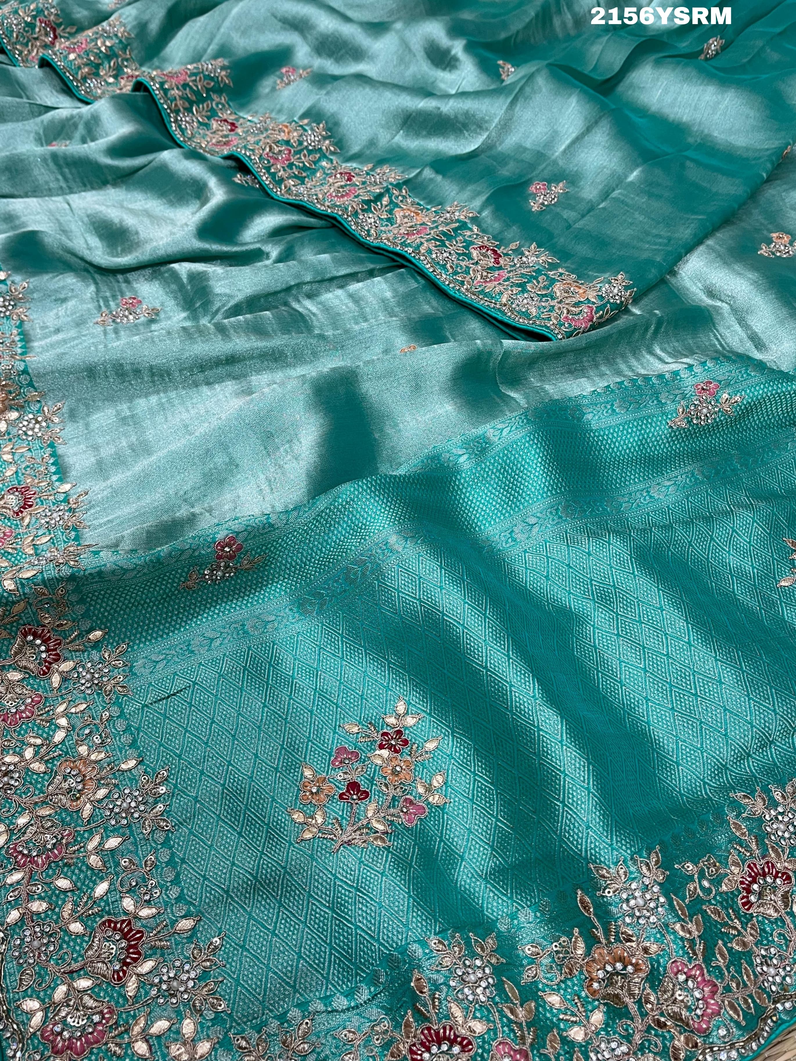 A sea green tissue silk saree with sequence embroidery work in a Bollywood style pattern.