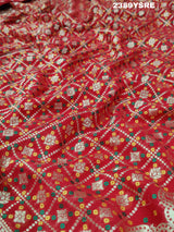 A red Banarasi style saree with gotapatti work, showcasing the detailed embroidery and pattern.