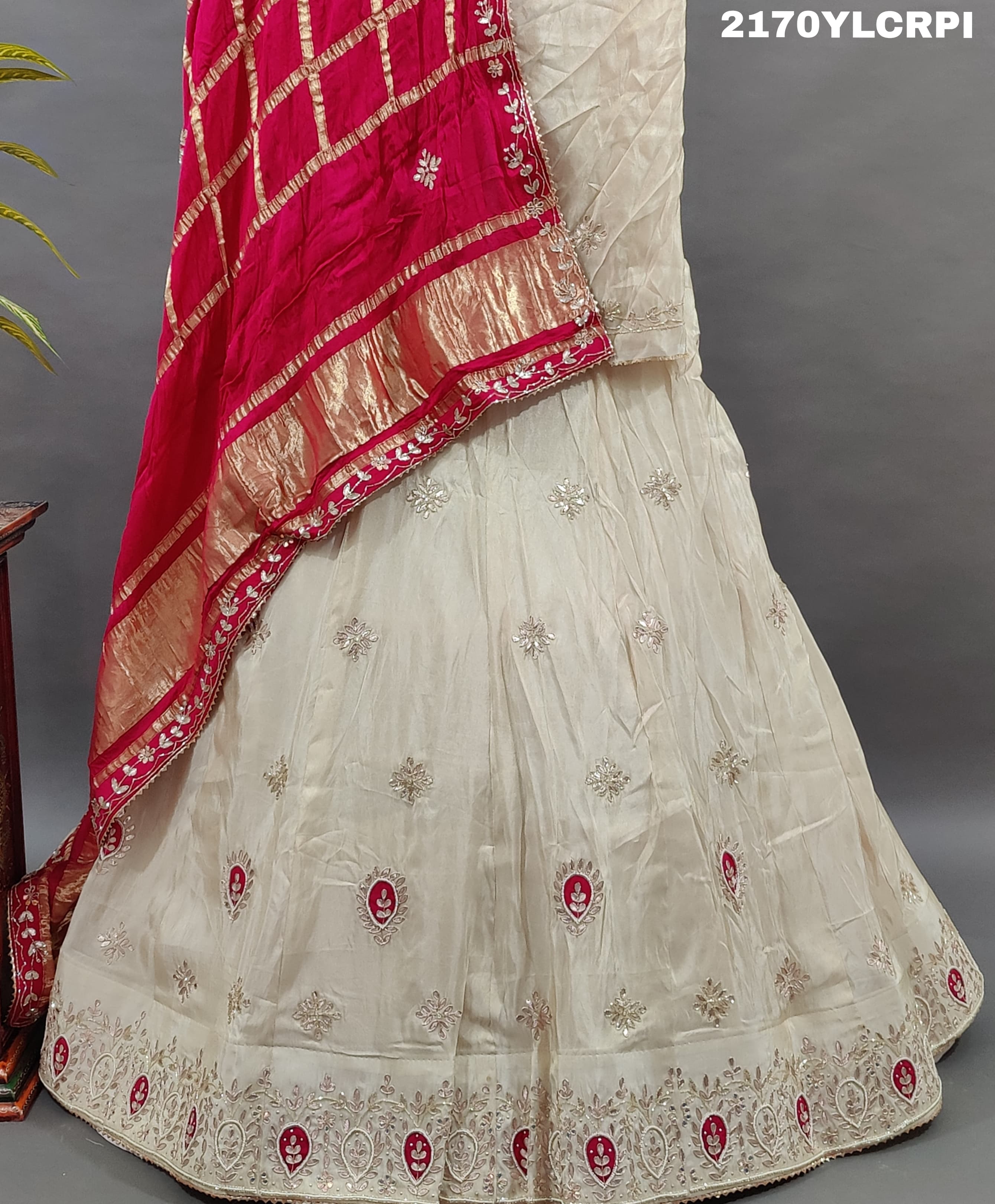 A cream-colored Lehenga with pink and gold embellishments