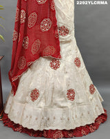 A traditional Indian lehenga with bandhani style patterns in cream and maroon colors