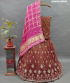 A brown and pink tissue organza silk lehenga with gota patti work
