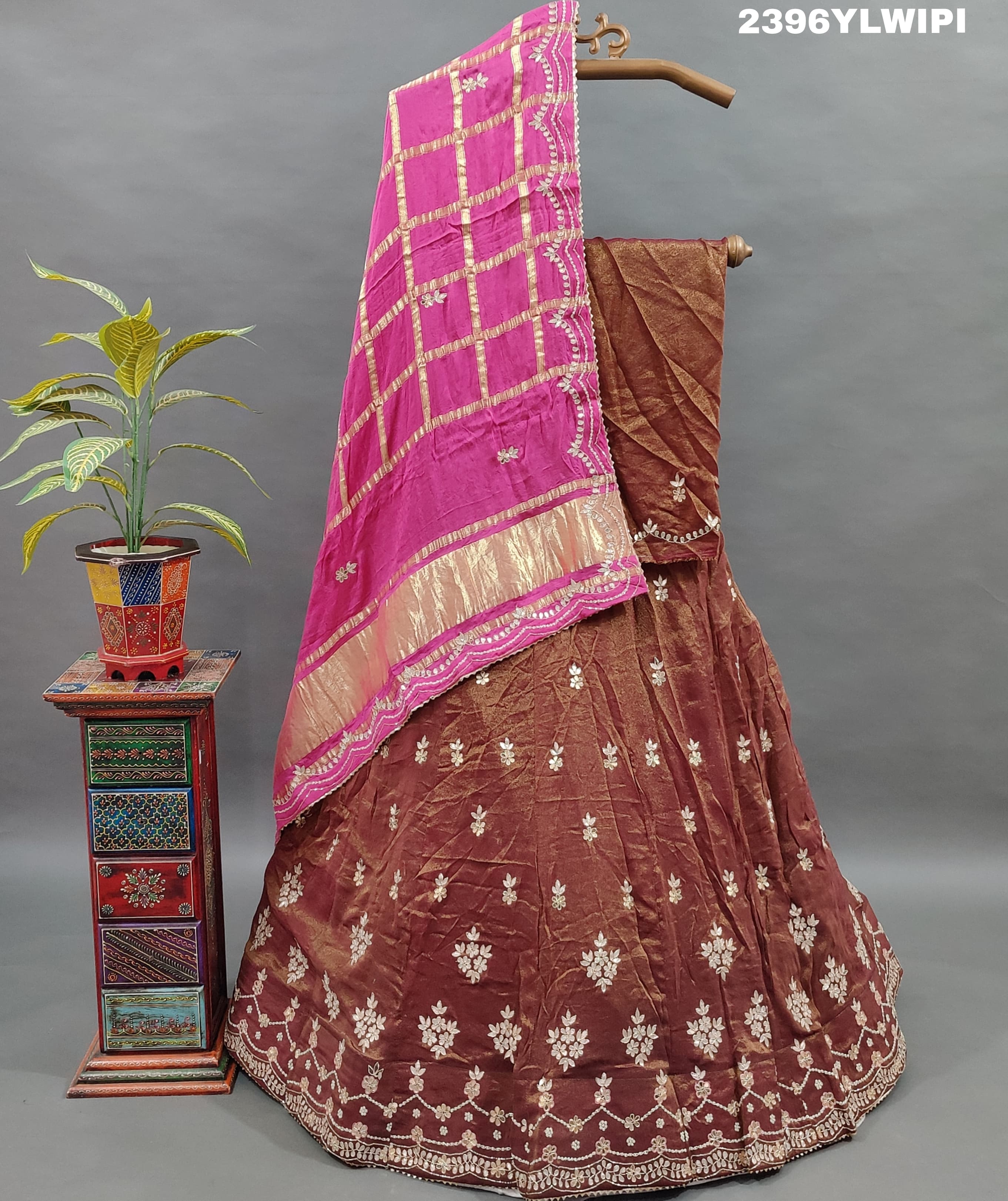 A brown and pink tissue organza silk lehenga with gota patti work