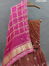 A brown and pink tissue organza silk lehenga with gota patti work