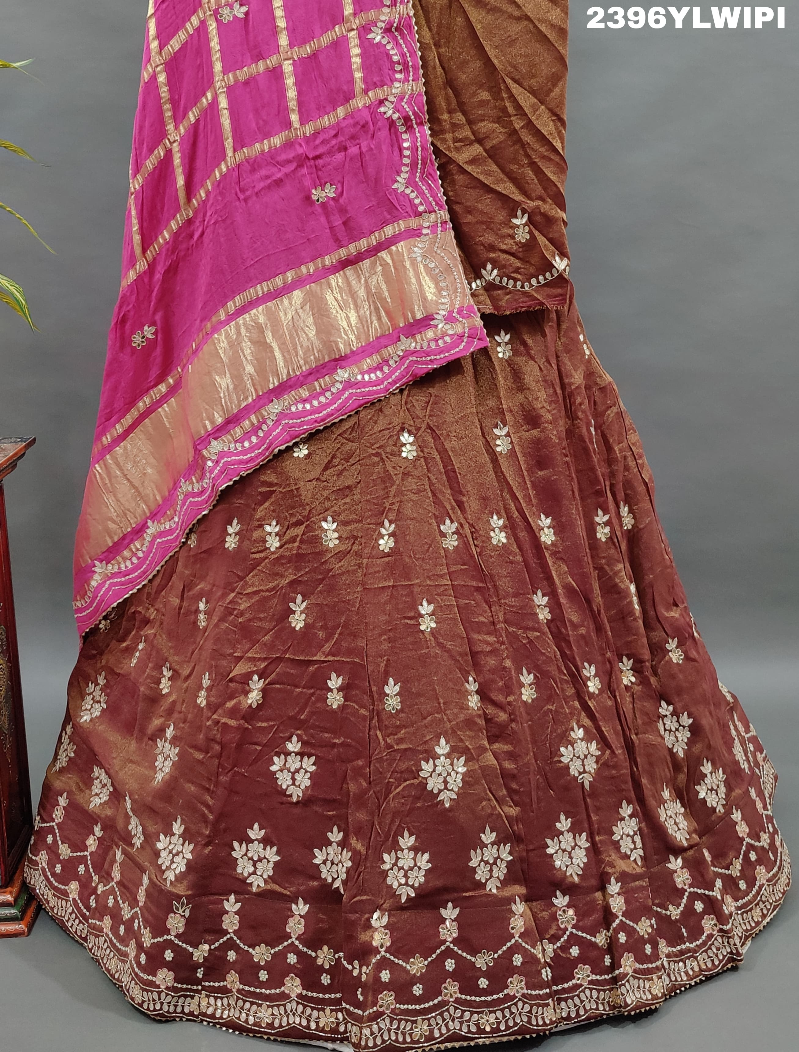A brown and pink tissue organza silk lehenga with gota patti work