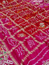 A pink saree with bandhani and gotapatti work, including intricate patterns and embellishments.