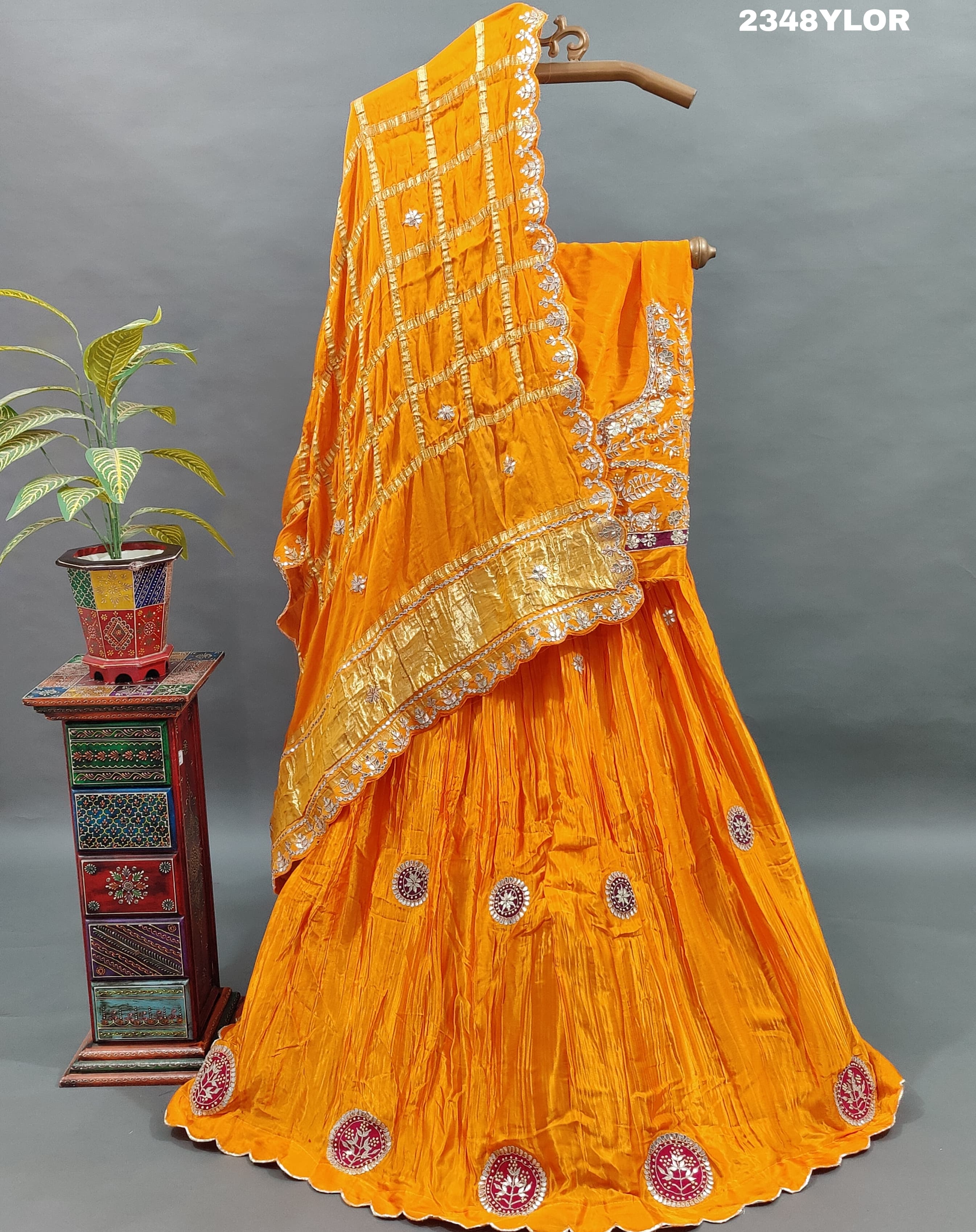 An elegant orange Gaji silk lehenga with Bollywood style Gotapatti work