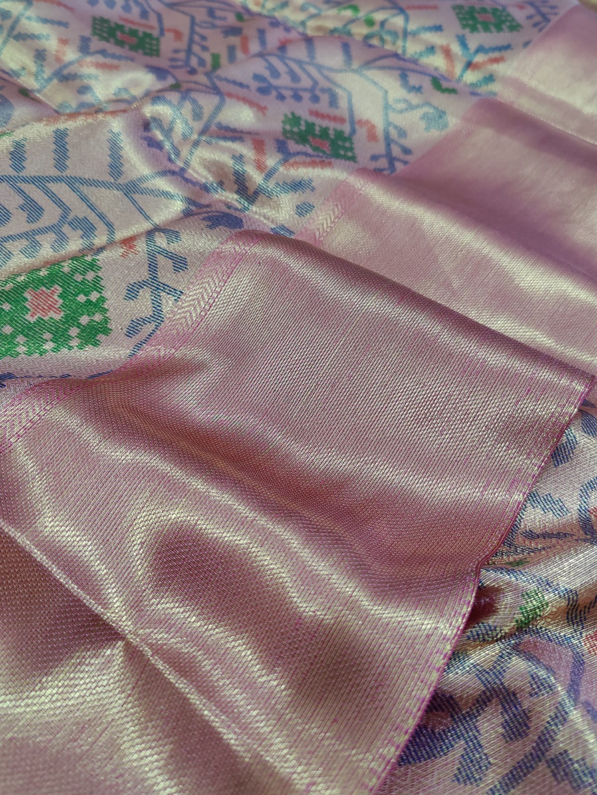  Banarasi silk saree with a printed floral pattern in pink and silver colors, showing detail and texture.