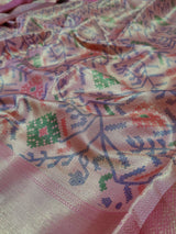  Banarasi silk saree with a printed floral pattern in pink and silver colors, showing detail and texture.