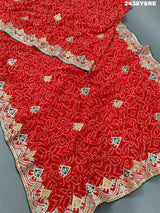 A red chiffon saree with bandhani pattern and gotapatti work