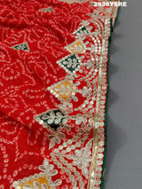 A red chiffon saree with bandhani pattern and gotapatti work