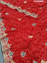 A red chiffon saree with bandhani pattern and gotapatti work